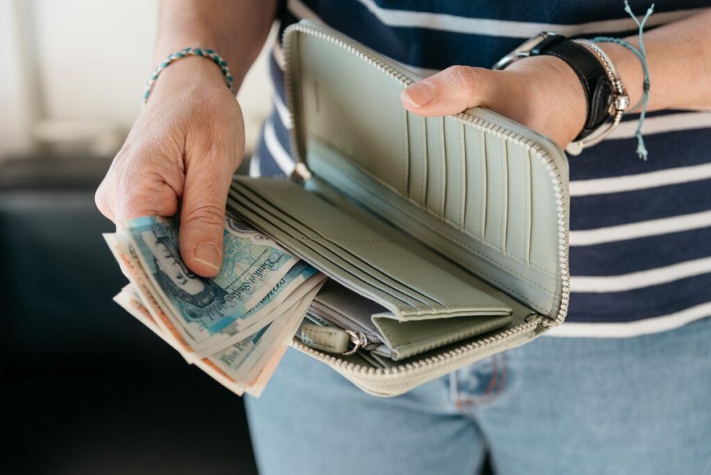 Close up of hand of woman taking out pounds from her purse