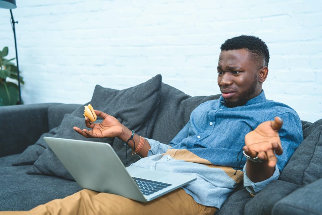 Confused man looking at his laptop.